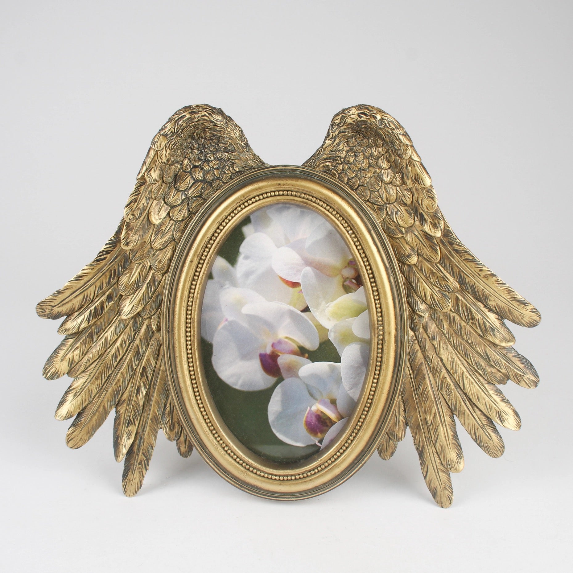 Gold winged frame with a floral image on a white background