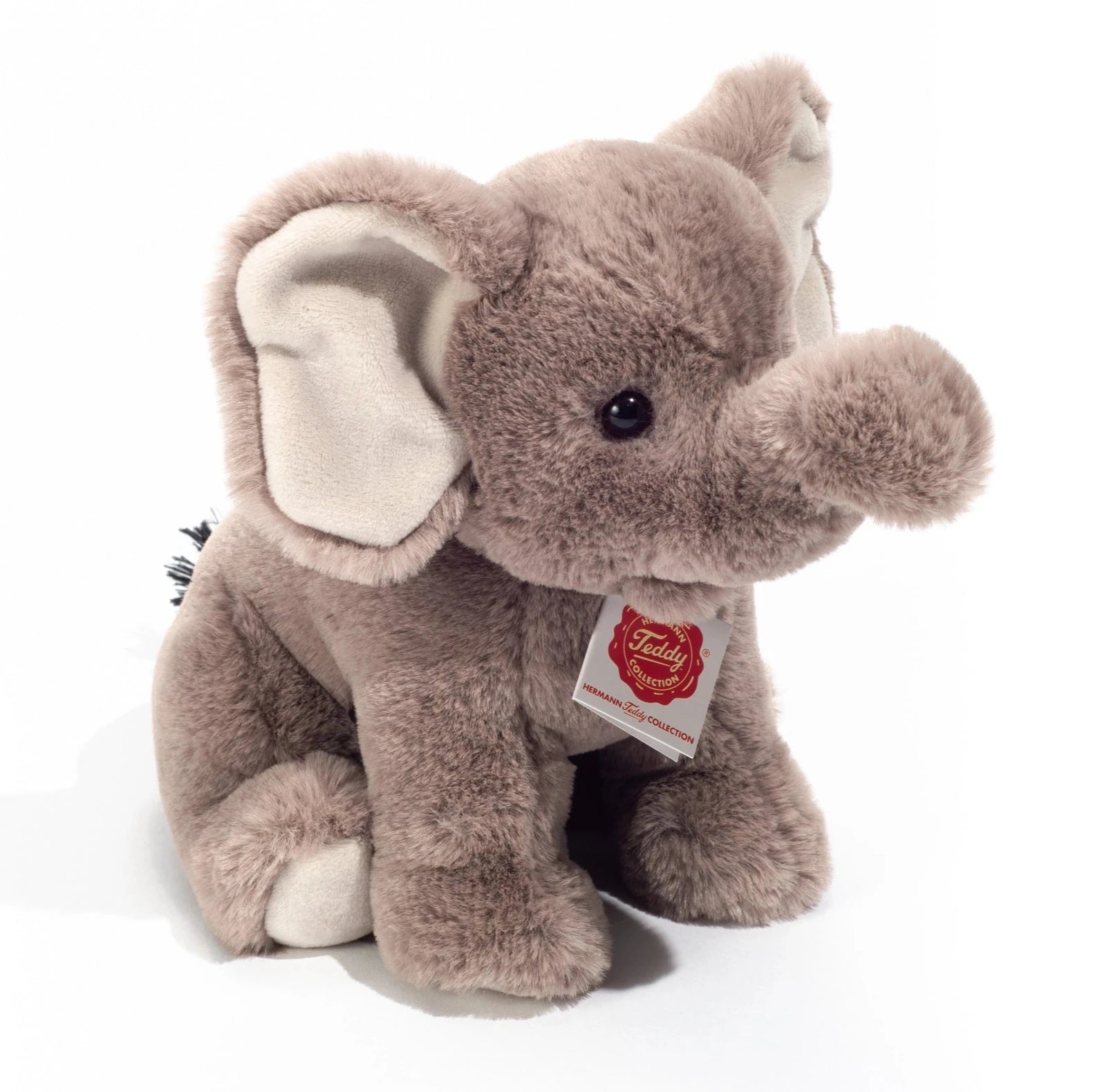Plush elephant toy with a visible tag on a white background