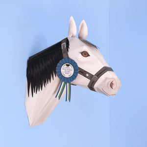 Horse head sculpture with a blue ribbon on a light blue background