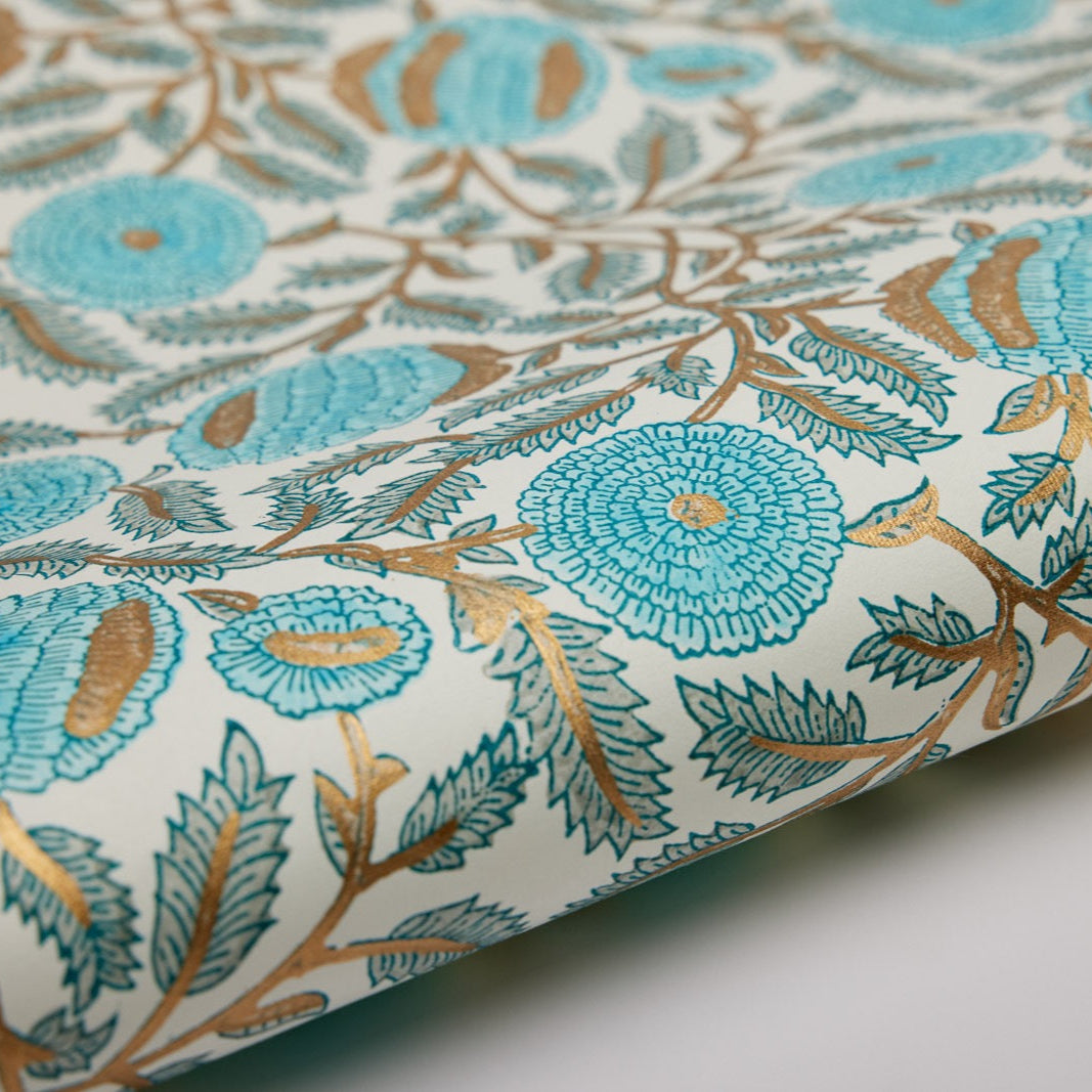 A sheet of cotton gift wrap with a floral pattern featuring blue and gold colors on a white background.