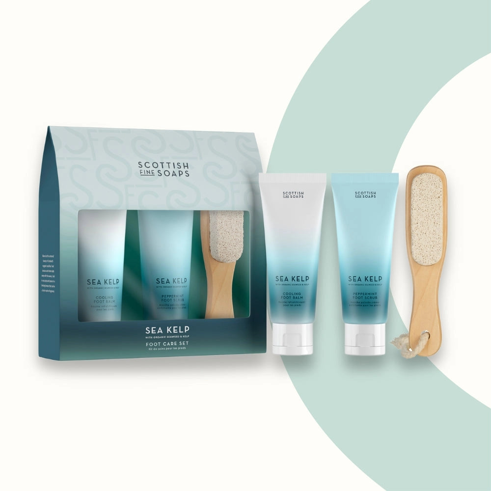 Scottish Fine Soaps Sea Kelp foot care set with two bottles, a brush, and packaging on a light green background.