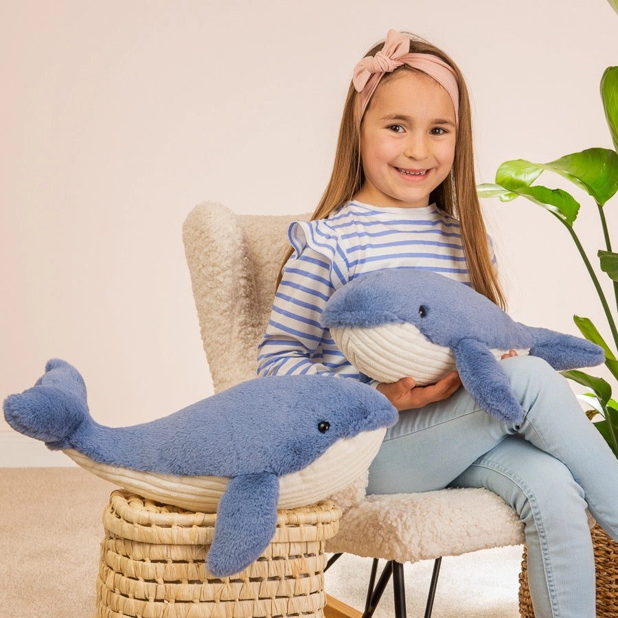 Young girl holding 2 Whale plush toys