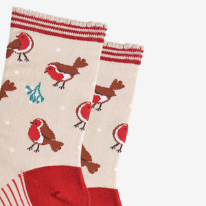 A pair of Cream socks decorated with Red Robins and striped top
